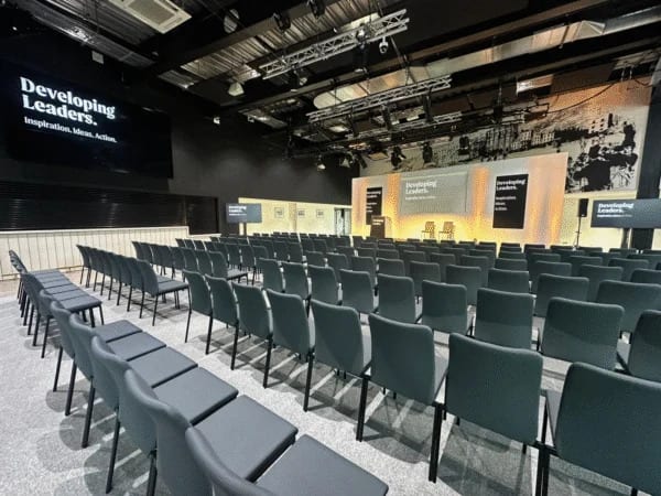 Theatre-style seating facing a branded conference stage set for an annual conference