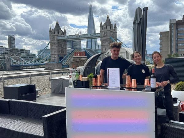 Staffed mobile bar at a rooftop reception with Tower Bridge in the background
